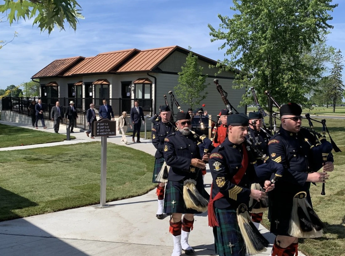A pipe band leads in delegates to the grand opening of the Homes for Heroes Village of tiny homes in Kingston in June 2024. (Elliot Ferguson /The Kingston Whig-Standard)