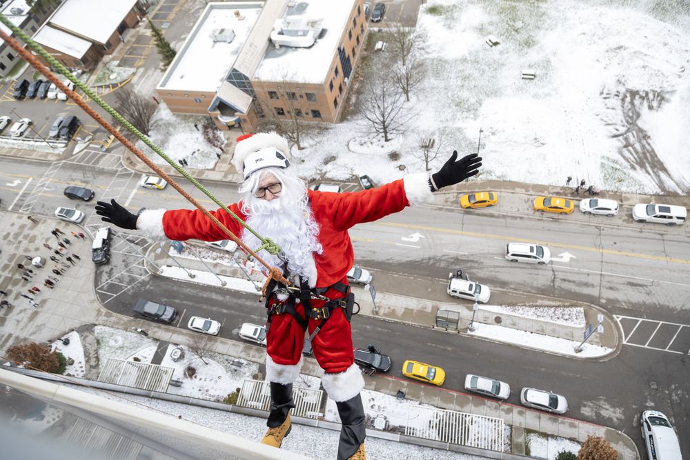 Santa Claus (Jim Kelly of the FM96 London morning show) hangs off the roof of Children's Hospital in London before rappelling down the side of the building and greeting patients inside on Thursday, Dec. 19, 2024. (Derek Ruttan/The London Free Press)