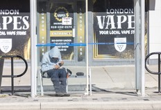 man smokes drugs in a bus shelter