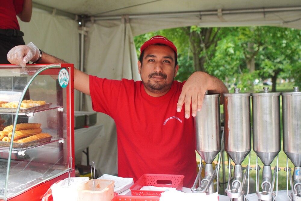 Jorge Cisneros stands behind the Ricos Churros booth