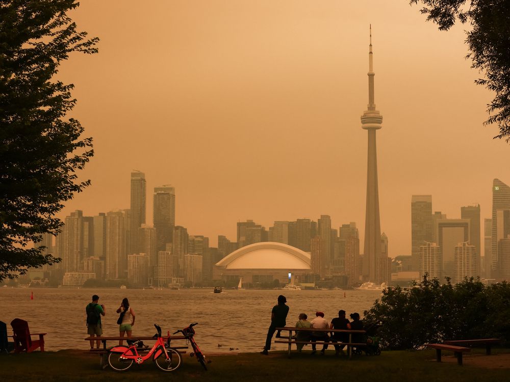 People look toward the downtown skyline from the Toronto Islands