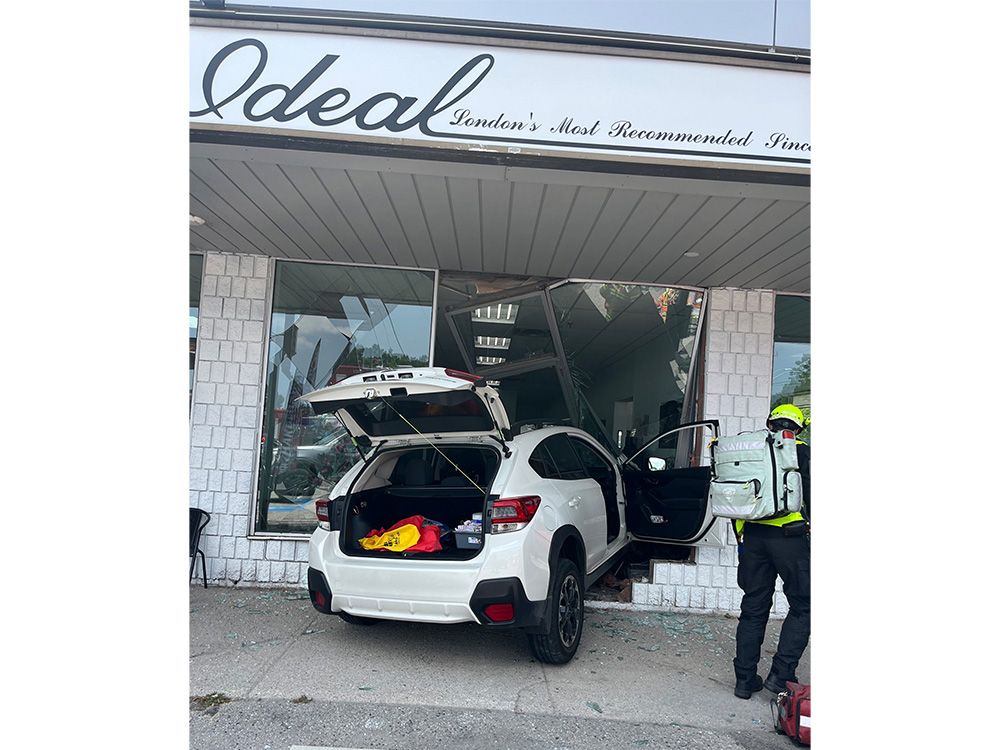 Car crashes into Springbank Drive storefront, trapping one