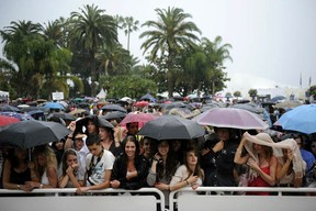 People wait under heavy rain before the screening of "Pirates of the Caribbean : On Stranger Tides" on May 14, 2011 in Cannes. (ANNE-CHRISTINE POUJOULAT/AFP/Getty Images)