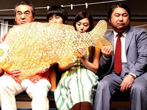 Four ghosts and one regular guy enjoy a giant candy fish in a scene from Korean comedy Hello Ghost.