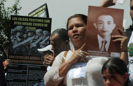 A woman holds a picture of a relative during a march against the false positives, massacres and forced disappearances by Colombian authorities on March 6, 2009, in Bogota. (MAURICIO DUENAS/AFP/Getty Images)