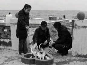 A family visits the grave of a young girl killed in a fire in Karamay, China, on the 13th anniversary of her death.
Photo courtesy dGenerate Films