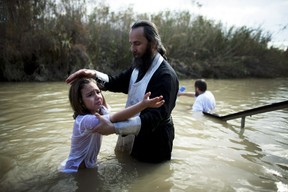 QASR AL YAHUD, WEST BANK - JANUARY 19:  (ISRAEL OUT) An Orthodox Christian child is baptized during Epiphany celebrations in the Jordan River January 19, 2012 at the Qasir al-Yahud baptismal site near Jericho, in the West Bank. Thousands of pilgrims gathered for the annual celebration at the site that the Eastern churches believes Jesus was baptised by John.  (Photo by Uriel Sinai/Getty Images)