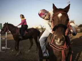 Palestinian women ride horses at the Al-Furusia riding centre in Gaza City on January 10, 2012. Opened since 2002 but under a new management for the past few months, the centre caters to a small number of women who practice horse riding despite the strict social and cultural norms in the Hamas-run strip. (MARCO LONGARI/AFP/Getty Images)