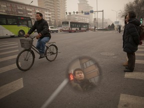 Pedestrians stand before heavy traffic at an intersection in Beijing on January 18, 2012. The US embassy which has its own pollution measuring system, and which rates anything over 150 as unhealthy, was showing an index of 403, or 'hazardous'. (AFP PHOTO / ED JONES)
