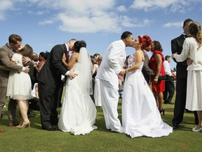 WEST PALM BEACH, FL - FEBRUARY 14:  (L-R) Jonah Klemm-Toole kisses his new wife, Elena Pizano, Kenny Dornhoefer kisses his new wife, Jaya Ganaishalm and Manuel Fuentes kisses his new wife, Monika Juarbe after being wed during a group Valentine's day wedding at the National Croquet Center on February 14, 2012 in West Palm Beach, Florida. The group wedding ceremony is put on by the Palm Beach Country Clerk & Comptroller's office and 30 couples to tied the knot. (Photo by Joe Raedle/Getty Images)