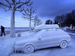 A man walks past an ice covered car on the frozen waterside promenade at Lake Geneva in the city Versoix, near Geneva on early February 5, 2012. The death toll from the vicious cold snap across Europe has risen to more than 260, with the winter misery set to hit thousands of those seeking to escape it as air traffic was hit.    (FABRICE COFFRINI/AFP/Getty Images)