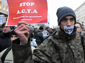 Internet activists protest against the international copyright agreement ACTA , the Anti-Counterfeiting Trade Agreement, in front of the European Parliament office in Warsaw, Poland, Tuesday, Jan. 24, 2012. The Polish government plans to sign the agreement and Poland's support for ACTA has sparked days of protest, including attacks on government sites, by groups who fear it could lead to online censorship. (AP Photo/Alik Keplicz)