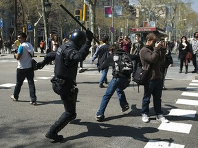 BARCELONA, SPAIN - MARCH 29: Riot police clash with demonstrators during rioting as a 24-hour strike is called, on March 29, 2012 in Barcelona, Spain. Spanish workers staged a general strike to protest the government's latest labour reforms, which are designed to help Spain lower its deficit within EU limits. (Photo by David Ramos/Getty Images)