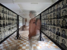 A tourist looks at portraits of victims of the Khmer Rouge at the Tuol Sleng genocide museum in Phnom Penh on February 2, 2009. Up to two million people were executed or died of starvation and overwork as the Khmer Rouge dismantled modern Cambodian society during its rule in a bid to forge a communist utopia.  (TANG CHHIN SOTHY/AFP/Getty Images)