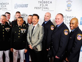 Actor Robert Downey Jr. (C) poses with U.S. Marines and New York City firefighters at The Avengers premiere during the 2012 Tribeca Film Festival on April 28, 2012 in New York City. (Photo by Andrew H. Walker/Getty Images for Bombay Sapphire)