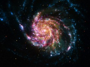 This NASA image obtained May 25, 2012, of the Pinwheel Galaxy, or M101, combines data in the infrared, visible, ultraviolet and X-rays from four of NASA's space telescopes. The view shows that both young and old stars are evenly distributed along M101's tightly wound spiral arms. Such composite images allow astronomers to see how features in one part of the light spectrum match up with those seen in other parts. The Pinwheel galaxy is in the constellation of Ursa Major (also known as the Big Dipper). It is about 70 percent larger than our own Milky Way galaxy, with a diameter of about 170,000 light-years, and sits at a distance of 21 million light-years from Earth. This means that the light we're seeing in this image left the Pinwheel galaxy about 21 million years ago -- many millions of years before humans ever walked the Earth. The red colors in the image show infrared light, as seen by the Spitzer Space Telescope. These areas show the heat emitted by dusty lanes in the galaxy, where stars are forming. The yellow component is visible light, observed by the Hubble Space Telescope. Most of this light comes from stars, and they trace the same spiral structure as the dust lanes seen in the infrared. The blue areas show ultraviolet light, given out by hot, young stars that formed about 1 million years ago. The Galaxy Evolution Explorer, which NASA recently loaned to the California Institute of Technology in Pasadena, Calif., captured this component of the image. Finally, the hottest areas are shown in purple, where the Chandra X-ray observatory observed the X-ray emission from exploded stars, million-degree gas and material colliding around black holes. AFP PHOTO/NASA/HANDOUT/