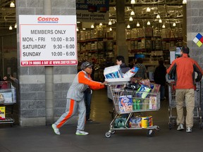 Customers look over items to purchase at a Costco Wholesale Corp. store in San Francisco, California, U.S., on Tuesday, Dec. 6 , 2011. Photographer: David Paul Morris/Bloomberg