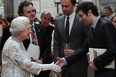 Britain's Queen Elizabeth II meets actor Michael Sheen as she visits the Royal Academy of Arts in central London on May 23, 2012.   (The very tall man in the middle is actor Tom Hiddleston, but no one told the  photographer, evidently. Since he is so tall, I guess  it was not possible to get the top of his head and the queen's hand into the same horizontal photo.  Michael Sheen and Tom Hiddleston worked together in Woody Allen's movie Midnight in Paris. Hiddleston went to Eton with the queen's grandson Prince William. Hiddleston plays the evil, yet very popular, Loki in the movie The Avengers, which is in cinemas now.)   (CARL COURT/AFP/GettyImages)