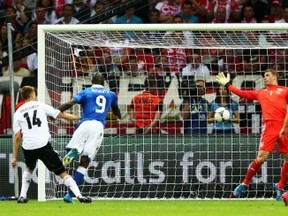 WARSAW, POLAND - JUNE 28:  Mario Balotelli (2nd L) of Italy jumps next to Holger Badstuber (L) of Germany to score the opening goal past Manuel Neuer of Germany during the UEFA EURO 2012 semi final match between Germany and Italy at National Stadium on June 28, 2012 in Warsaw, Poland.  (Photo by Michael Steele/Getty Images)