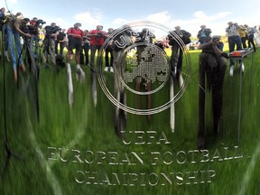 Journalists are reflected in the EURO 2012 tournament cup. Photo by Sergei Supinsky, AFP via Getty Images