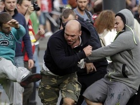 Fans clash prior to the Euro 2012 soccer championship Group A match between Poland and Russia in Warsaw, Poland, Tuesday, June 12, 2012. (AP Photo/Gero Breloer)