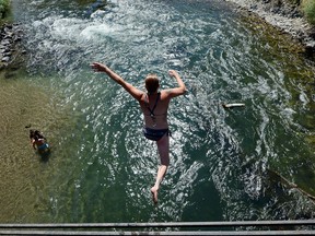 SUN VALLEY, ID - JULY 09:  Lindsey Sehofield jumps into the Big Wood River from an old train bridge to cool off on July 9, 2012 in Sun Valley, Idaho. According to a report from the National Oceanic and Atmospheric Administration (NOAA) the first six months of 2012 accounted for the warmest January-through-June period on record (since record keeping began in 1895) for the U.S. mainland.  (Photo by Kevork Djansezian/Getty Images)