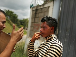 TEGUCIGALPA, HONDURAS - JULY 16: A health worker from Doctors Without Borders tries to persuade a teenager living on the street to visit a hospital after he was hit by a car on July 16, 2012 in Tegucigalpa, Honduras. Honduras now has the highest per capita murder rate in the world and its capital city, Tegucigalpa, is plagued by violence, poverty, homelessness and sexual assaults. With an estimated 80% of the cocaine entering the United States now being trans-shipped through Honduras, the violence on the streets is a spillover from the ramped rise in narco-trafficking. The non-governmental organization Doctors Without Borders has set up a program in the capital that looks to provide medical and psychological care to the homeless population. Each day a team goes out into the streets to meet with vulnerable groups of homeless to assess their needs.  (Photo by Spencer Platt/Getty Images)