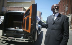 MOUNT VERNON, NY - JULY 25:  Driver Abraham Tucker holds open the door of the 1930 Rolls-Royce hearse carrying the body of Harlem restaurateur Sylvia Woods after her funeral at Grace Baptist Church on July 25, 2012 in Mount Vernon, New York. Woods owned the famed Sylvia's Restaurant frequented by African-American celebrities and died on July 19 at the age of 86. (Photo by Mario Tama/Getty Images)