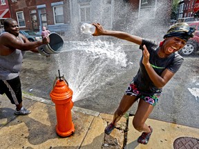 People play in water from an open fire hydrant during the afternoon heat, Wednesday, July 18, 2012, in Philadelphia. Temperatures are expected to reach into the high 90s Wednesday. (AP Photo/Matt Rourke)