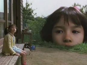 Sachiko sits under the gaze of her giant doppelganger, in Japanese movie A Taste of Tea.