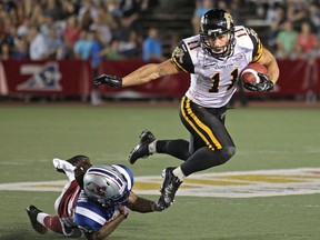 MONTREAL, QUE.: AUGUST 23, 2012 -- Montreal Alouettes Dwight Anderson, left, trips up Hamilton TigerCats Samuel Giguere in Canadian Football League game in Montreal, Thursday August 23, 2012.                 (John Mahoney/THE GAZETTE)