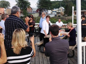 Liberal leader Jean Charest's wife, Michele Dionne (R), sits down with a plate of onion rings in St. Raymond on Sunday. What's missing here? TV cameras. Credit: Monique Muise