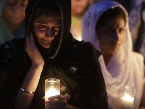 Mourners cry during a candlelight vigil at the Sikh Temple in Brookfield, Wisconsin August 6, 2012. The gunman who killed six worshipers at a Sikh temple in Wisconsin was identified as a 40-year-old U.S. Army veteran and authorities said they were investigating possible links to white supremacist groups and his membership in skinhead rock bands. The assailant, shot dead by police at the scene on Sunday, was identified as Wade Michael Page.