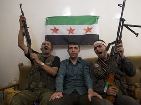 A suspected pro-Syrian regime policeman (C) sits amidst members of Liwa al-Tawhid rebel group following his arrest in Aleppo on September 20, 2012. More than 29,000 people have been killed in violence in Syria since an anti-government uprising broke out in March last year meeting with a bloody crackdown, a human rights group said. MIGUEL MEDINA/AFP/GettyImages