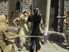 Indian police women beat female Kashmiri nursing students with batons during their arrest at a protest against their exam results in Srinagar on September 26, 2012.  Indian police used batons to disperse a sit-in protest by female Kashmiri nursing students and detained some half a dozen during a protest against the results of their third year examinations which most of the students failed. TAUSEEF MUSTAFA/AFP/GettyImages