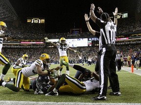 Officials signal after Seattle Seahawks wide receiver Golden Tate pulled in a last-second pass from quarterback Russell Wilson to defeat the Green Bay Packers 14-12 in an NFL football game, Monday, Sept. 24, 2012, in Seattle. The touchdown call stood after review. (AP Photo/The Seattle Times, John Lok)