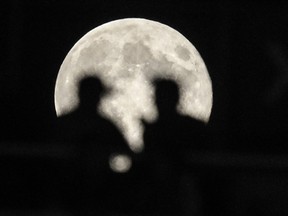 MONTREAL, QUE.: AUGUST 31, 2012-- Football fans silhouetted against a full moon watch the CLF football match between the Montreal Alouettes and the BC Lions at Molson Stadium in Montreal on Friday, August 31, 2012. (Dario Ayala/THE GAZETTE)