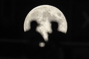 MONTREAL, QUE.: AUGUST 31, 2012-- Football fans silhouetted against a full moon watch the CLF football match between the Montreal Alouettes and the BC Lions at Molson Stadium in Montreal on Friday, August 31, 2012. (Dario Ayala/THE GAZETTE)