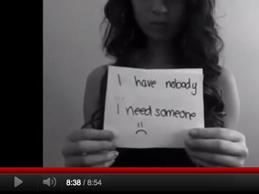 [PNG Merlin Archive] Bullied teenager holds a note in a video posted to YouTube