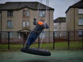 young boy plays in a play park near disused housing in the Hamiltonhill area on October 23, 2012 in Glasgow, Scotland. The Scottish National Party (SNP) have announced a welfare fund to provide emergency support to disadvantaged people who are struggling with issues such as unemployment, low income, poor health and lack of educational qualifications.