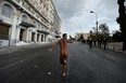 A naked demonstrator flashes the victory sign while running in Athens during a demonstration against the vist of the German Chancellor Angela Merkel on October 9, 2012.   Athens went into security lockdown for a landmark visit by German Chancellor Angela Merkel, an austerity hate figure in Greece whose arrival will be greeted by union and opposition party protests. Thousands of police fanned out across the capital, creating a large safety zone for Merkel's meetings with Prime Minister Antonis Samaras and President Carolos Papoulias in which all gatherings and protests have been banned. ARIS MESSINIS/AFP/GettyImages