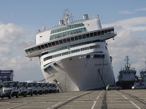 The ferry "Napoleon Bonaparte" of the Société Nationale Corse Mediterranee (SNCM),  tilts to the side against a quay, in the port of Marseille, Sunday, Oct. 28, 2012. The ferry broke its moorings due to gusts of wind blowing across the South of France, before running aground against a quay causing a breach in the hull. (AP Photo/Claude Paris)