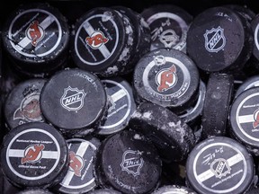 In this May 15, 2012, file photo, ice covered hockey pucks are shown at the New Jersey Devils practice rink in Newark, N.J. With the announcement by the NHL on Thursday that it has canceled the hockey season through Oct. 24, they may as well be paperweights. (AP Photo/Julio Cortez, File)