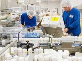 Workers are shown on the Centrum multivitamin packaging line at the Pfizer plant.