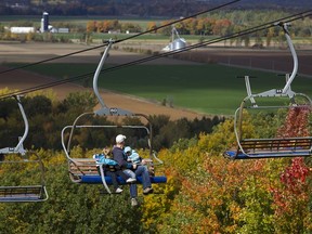 A man and children enjoy the view as they take the lift at Mont Rigaud during the Festival des Couleurs Rigaud in Rigaud on Oct. 7.