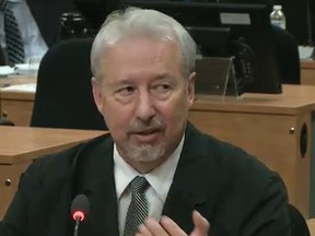 Former city of Montreal engineer Gilles Surprenant displays one of the palms he had regularly greased by crooked contractors as he testifies before the Charbonneau Commission into corruption in the construction industry. (screen shot from the Charbonneau Commission)