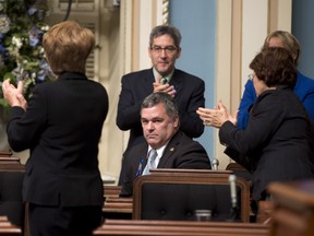 Happier days: then Quebec Environment Minister Daniel Breton, centre, sits while applauded by government members after he voted against a motion that forces him to appear at a legislature committee. A week later he was forced to resign over his incidents from his past. THE CANADIAN PRESS/Jacques Boissinot