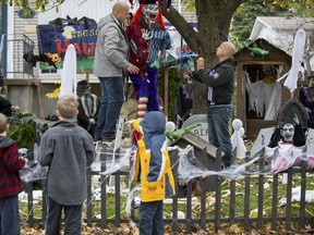 Brothers Brad, left, and Brent Smitheman install elaborate Halloween display. (Peter McCabe/THE GAZETTE)