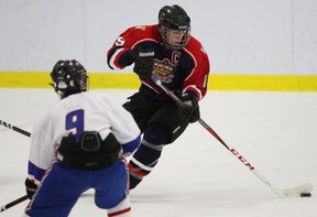 Michael Campoli of the West Island Royals handles the puck as Lakeshore's  Tommy Tanner advances towards him in a Oct. 28 bantam AA hockey game in Dollard.