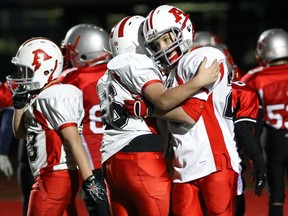 Sunny Letourneau (right) of the Alexander Cardinals is congratulated by teammate Andrew Pearson after scoring a touchdown against Lakeshore Cougars in  provincial AAA mosquito football final at Keith Ewenson Park in Lasalle on Saturday.